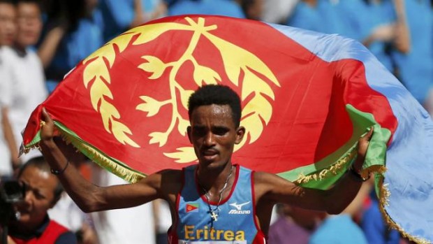 REFILE - CORRECTING BYLINEGhirmay Ghebreslassie of Eritrea celebrates with his country's flag after winning  the men's marathon at the 15th IAAF World Championships at the National Stadium in Beijing, China August 22, 2015.  REUTERS/Lucy Nicholson